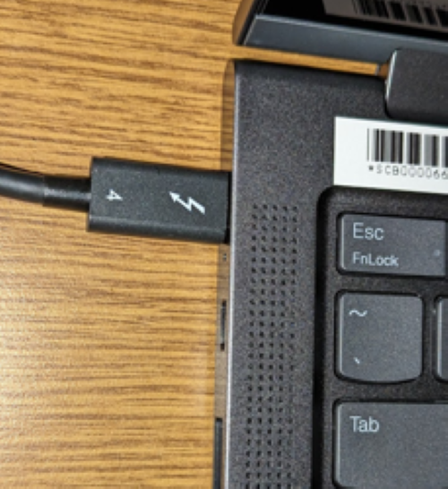 The power cable plugged into the side of a laptop